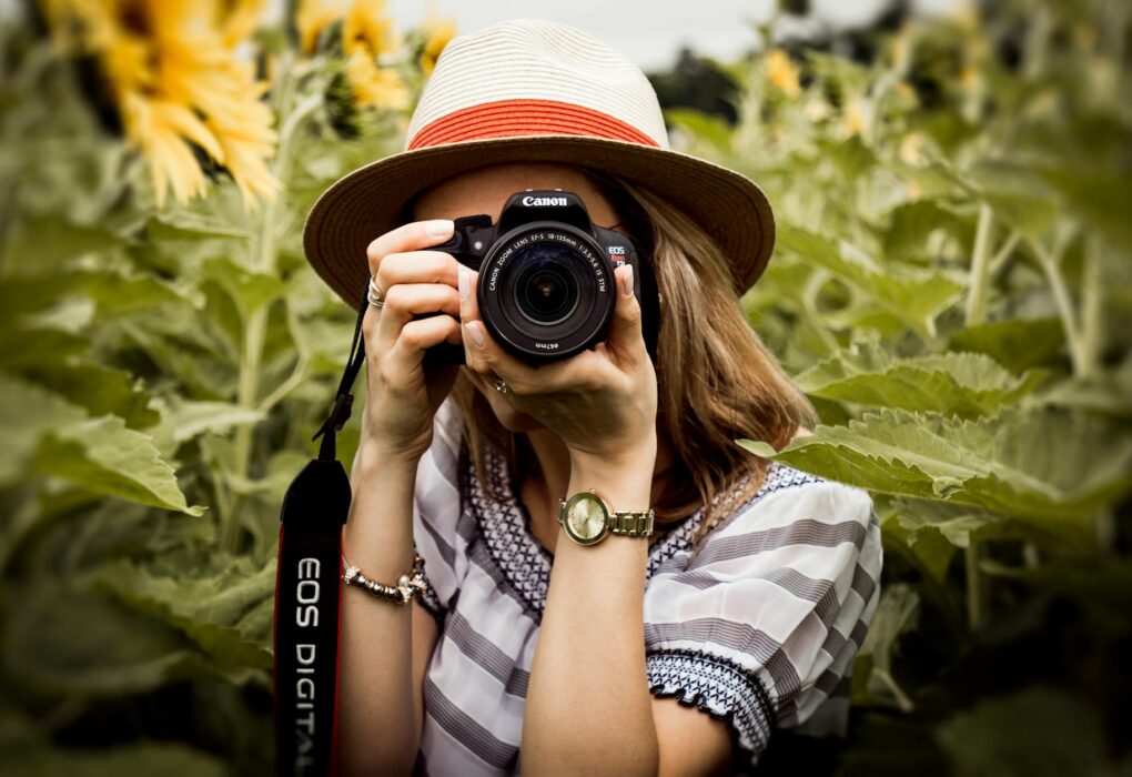 selective focus photography of woman holding dslr camera